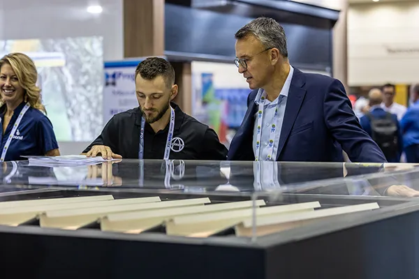Attendees examining sun shading products at an exhibitor booth