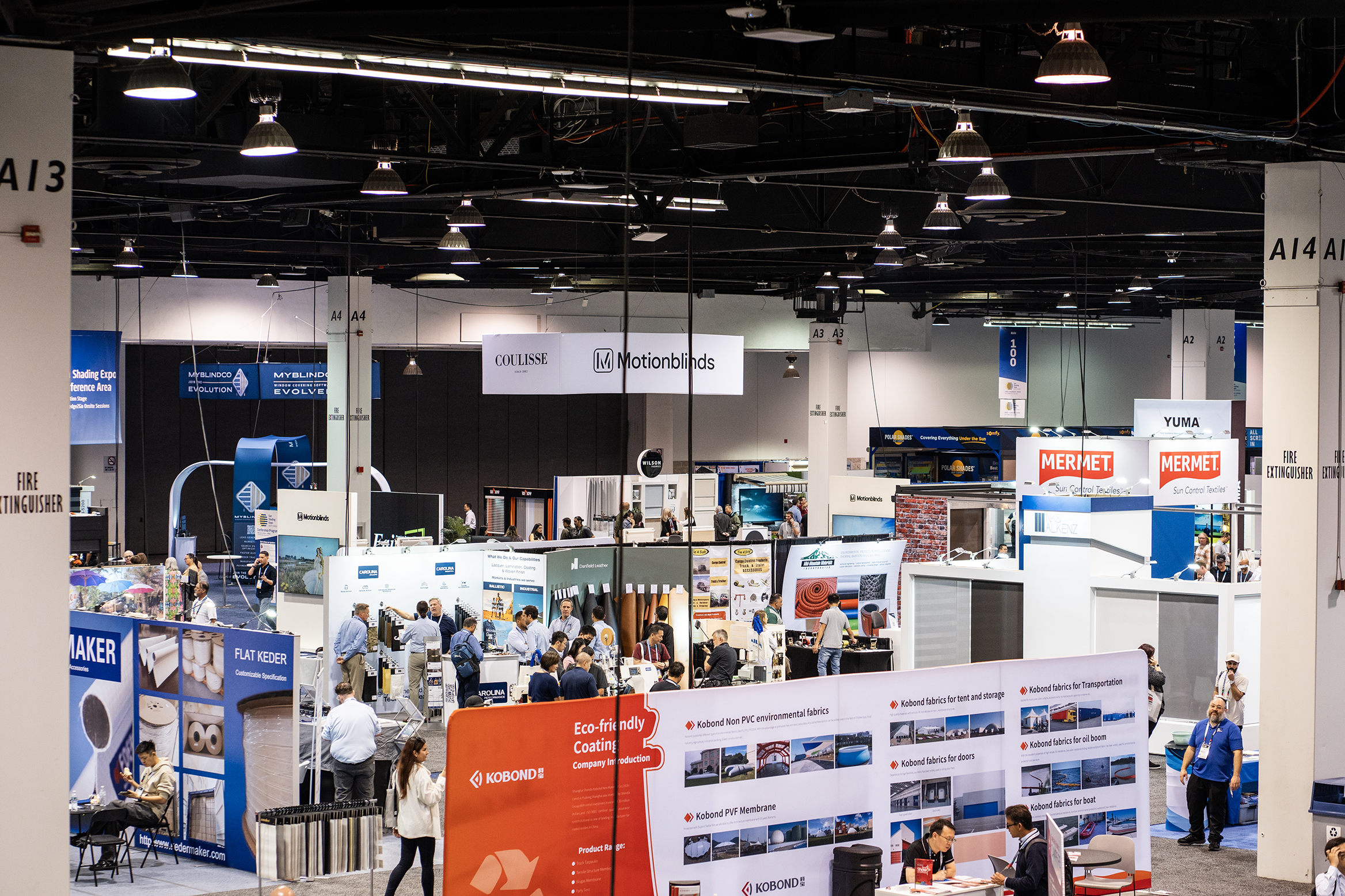 Attendees walking the busy Sun Shading Expo show floor among exhibitor booths