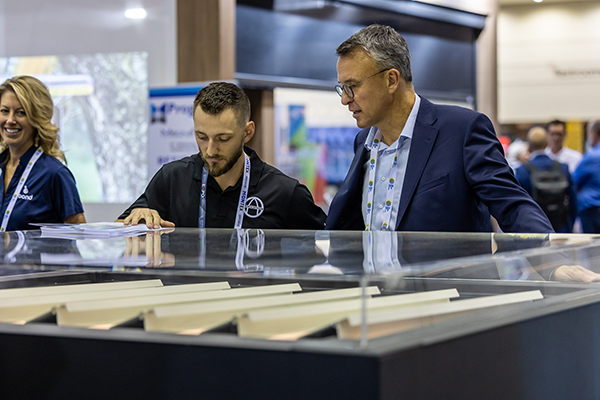 Attendees examining sun shading products at an exhibitor booth